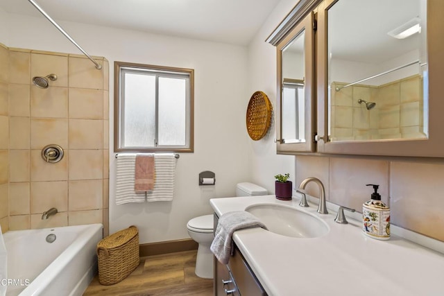 full bath with vanity, toilet, baseboards, washtub / shower combination, and wood finished floors
