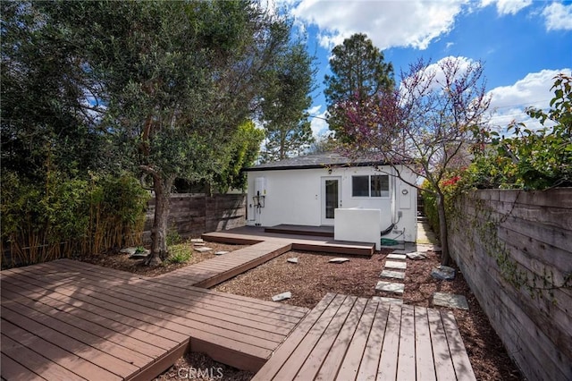 wooden deck with a fenced backyard