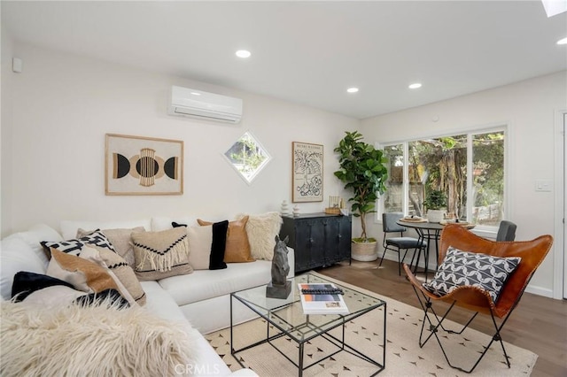living room featuring a wall mounted AC, baseboards, light wood-style floors, and recessed lighting