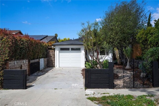 garage featuring driveway and fence