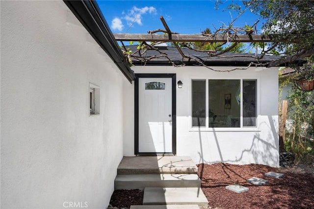 view of exterior entry featuring stucco siding