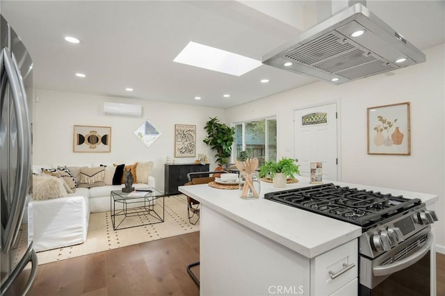 kitchen with range hood, a skylight, appliances with stainless steel finishes, open floor plan, and dark wood-style flooring