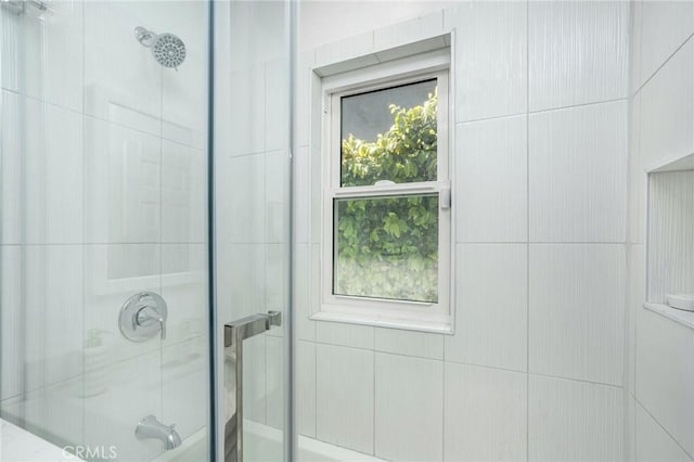 bathroom featuring tiled shower and a wealth of natural light
