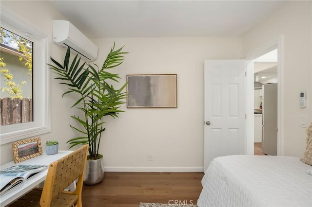 bedroom with baseboards, wood finished floors, and a wall unit AC