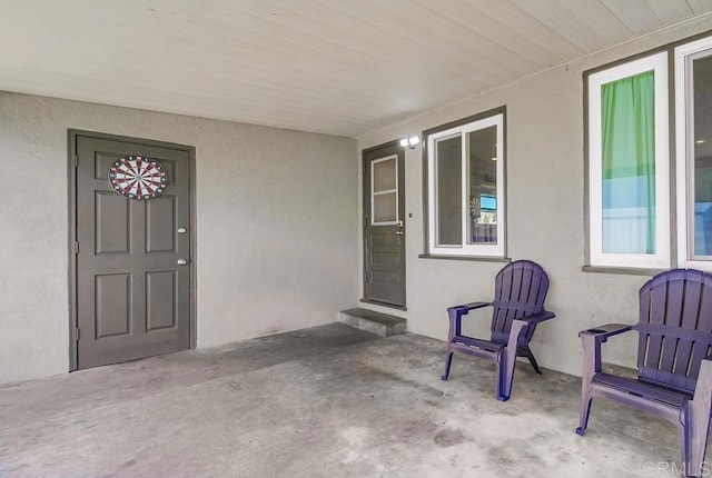 entrance to property featuring a patio area and stucco siding