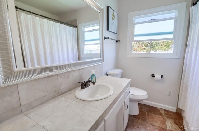 bathroom featuring baseboards, vanity, and toilet