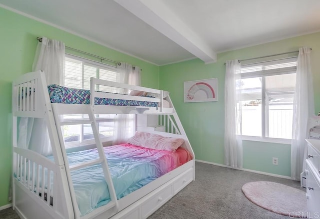 bedroom featuring baseboards, carpet flooring, beam ceiling, and multiple windows