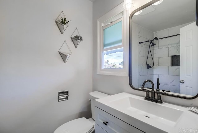 bathroom with toilet, vanity, and a shower