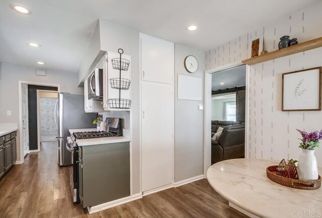 kitchen featuring recessed lighting, appliances with stainless steel finishes, dark wood-type flooring, and light countertops