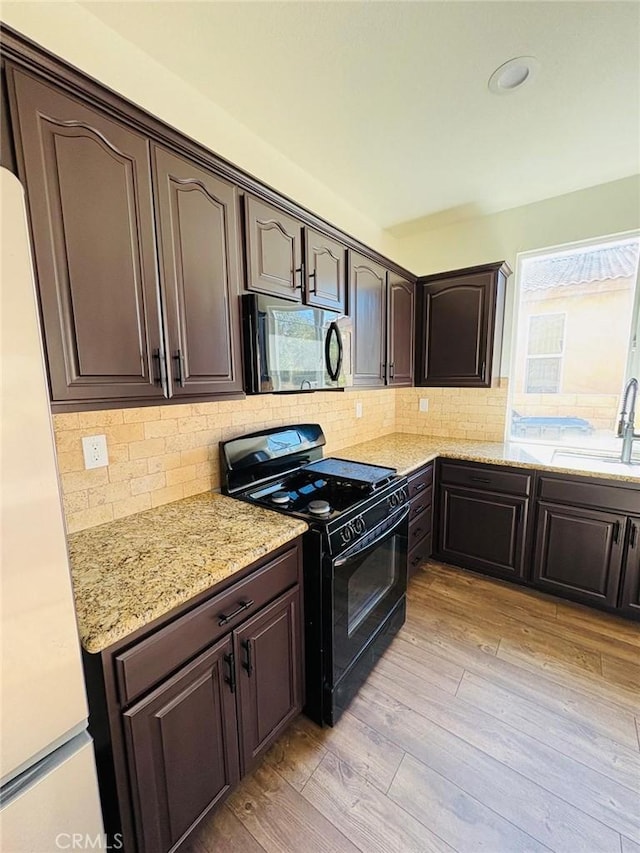 65565 Acoma Ave Unit 68, Desert Hot Springs, CA 92240 - kitchen featuring white fridge, a sink, dark brown cabinets, light wood finished floors, and gas stove