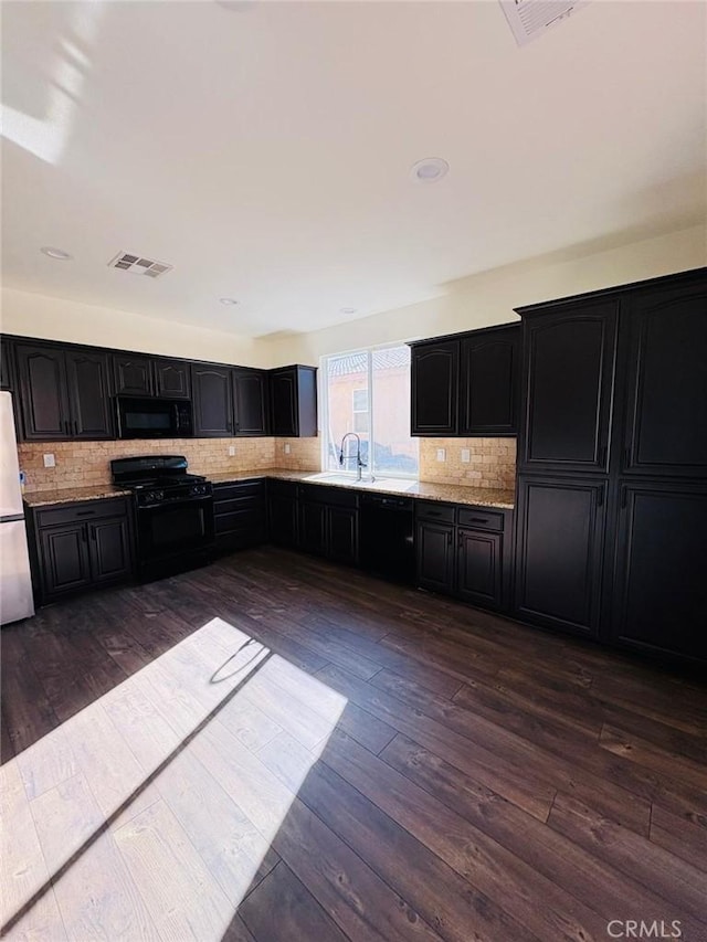 65565 Acoma Ave Unit 68, Desert Hot Springs, CA 92240 - kitchen featuring dark cabinets, visible vents, black appliances, a sink, and decorative backsplash