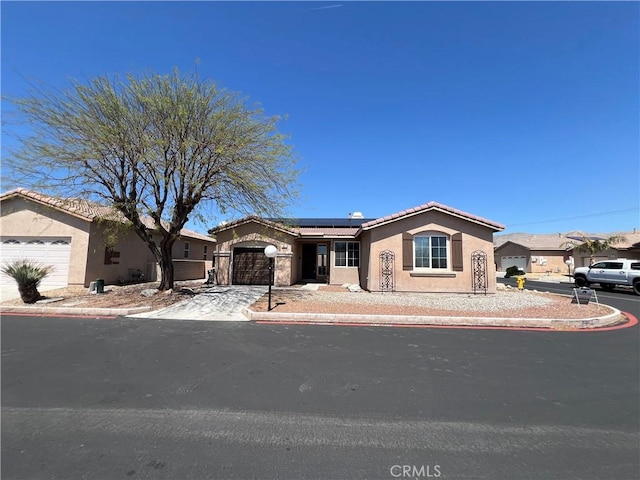 65565 Acoma Ave Unit 68, Desert Hot Springs, CA 92240 - ranch-style house with a garage, stucco siding, a tile roof, and solar panels
