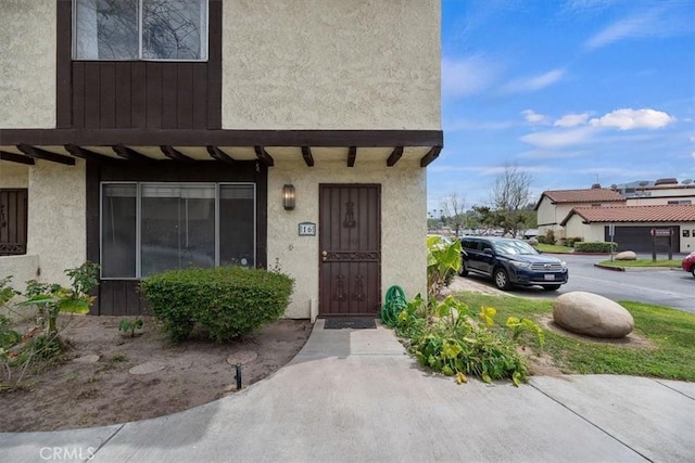 entrance to property featuring stucco siding