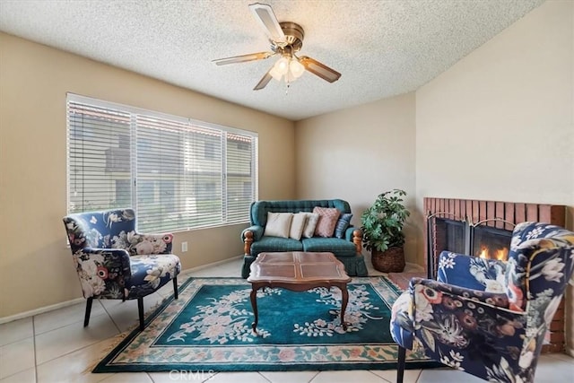 sitting room with a textured ceiling, ceiling fan, baseboards, and tile patterned floors