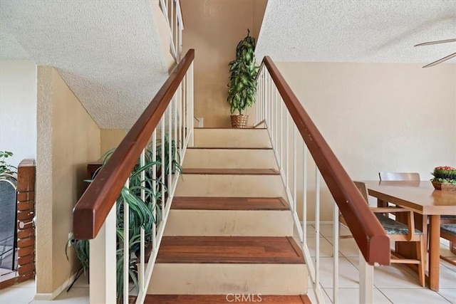 stairs with a textured ceiling and tile patterned flooring
