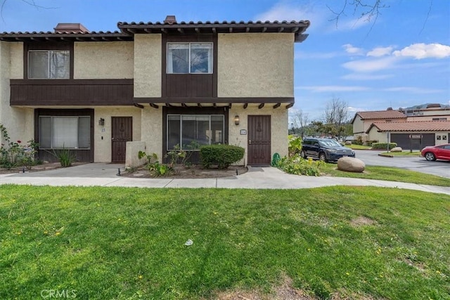 view of front of house with a front yard and stucco siding