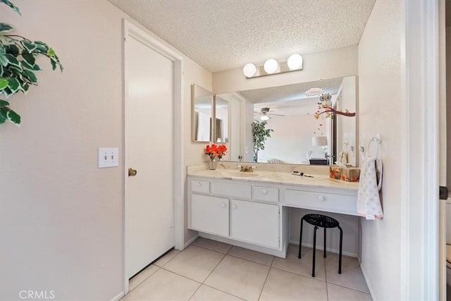 bathroom featuring baseboards, ceiling fan, a textured ceiling, vanity, and tile patterned floors