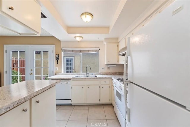 kitchen with a sink, light countertops, white appliances, and a wealth of natural light