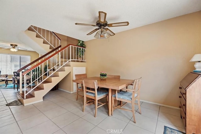 dining room featuring tile patterned floors, ceiling fan, baseboards, and stairway