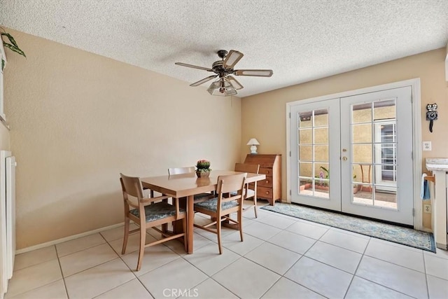 dining room with french doors, ceiling fan, baseboards, and a textured ceiling