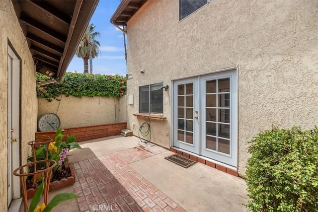 view of patio featuring french doors and fence