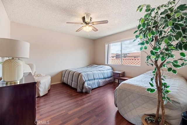 bedroom featuring baseboards, a ceiling fan, wood finished floors, and a textured ceiling