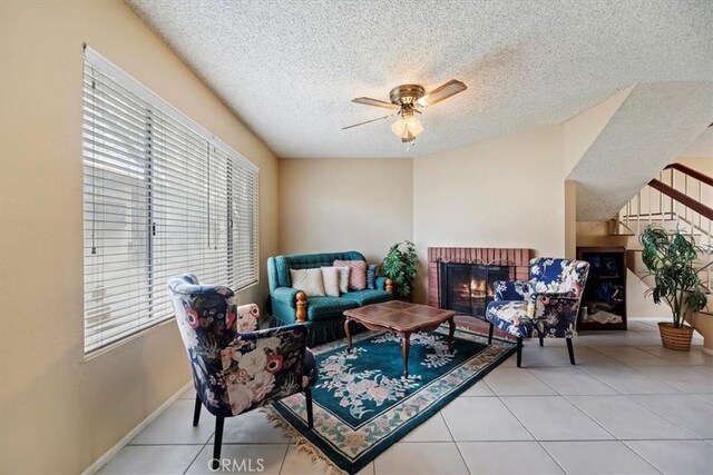 interior space with a wealth of natural light, a ceiling fan, tile patterned flooring, and a textured ceiling
