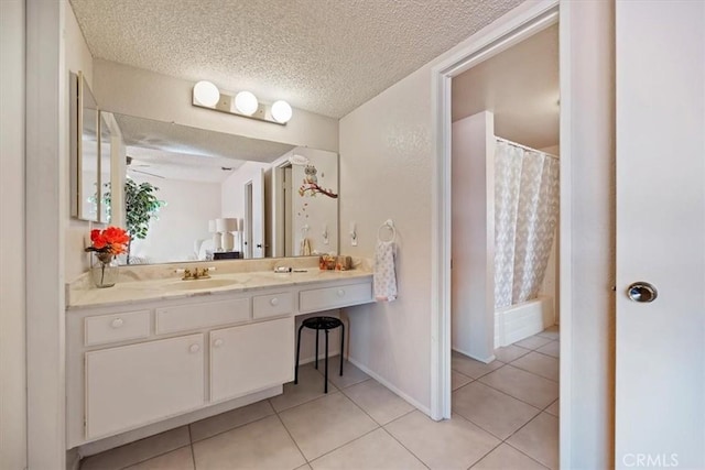 full bathroom with a shower with shower curtain, tile patterned floors, vanity, and a textured ceiling