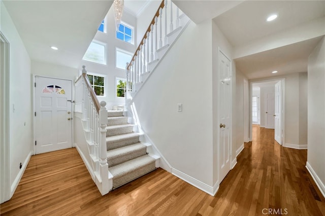 stairway with baseboards, recessed lighting, and wood finished floors