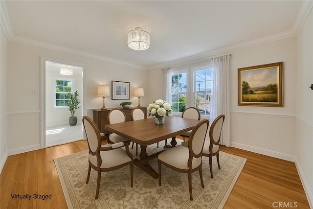 dining area with light wood-type flooring, baseboards, and ornamental molding