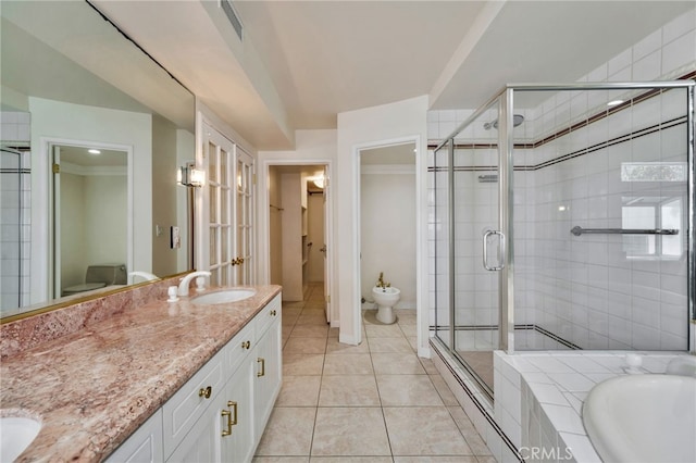 bathroom with a shower stall, toilet, a sink, tile patterned floors, and a bidet