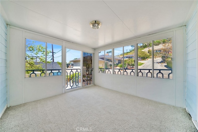unfurnished sunroom with carpet floors and a wealth of natural light
