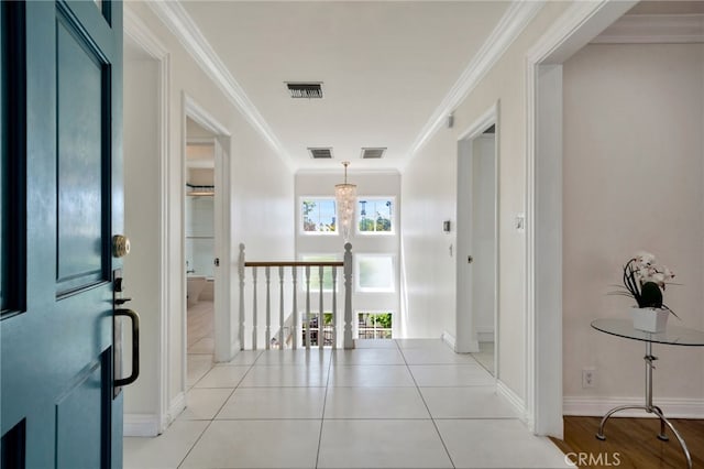 corridor featuring an upstairs landing, ornamental molding, and visible vents