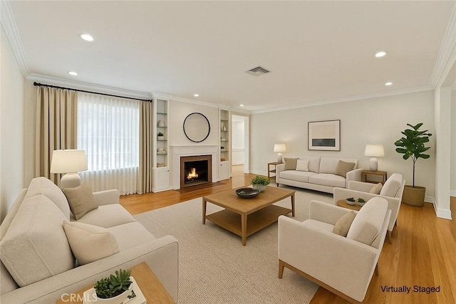 living room with crown molding, visible vents, recessed lighting, and light wood-style floors