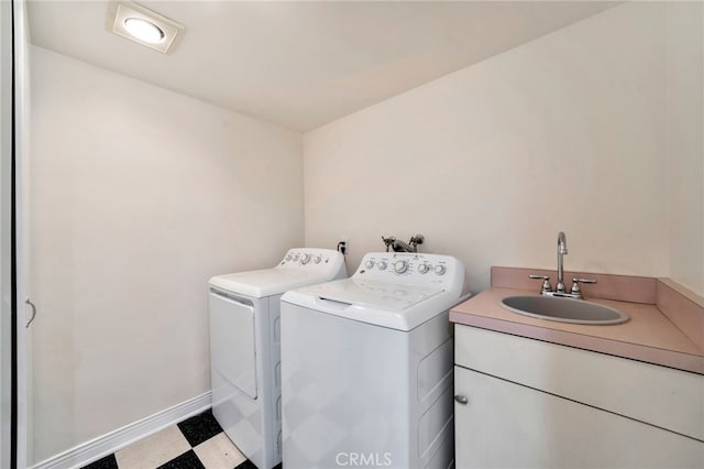 clothes washing area with laundry area, separate washer and dryer, a sink, tile patterned floors, and baseboards