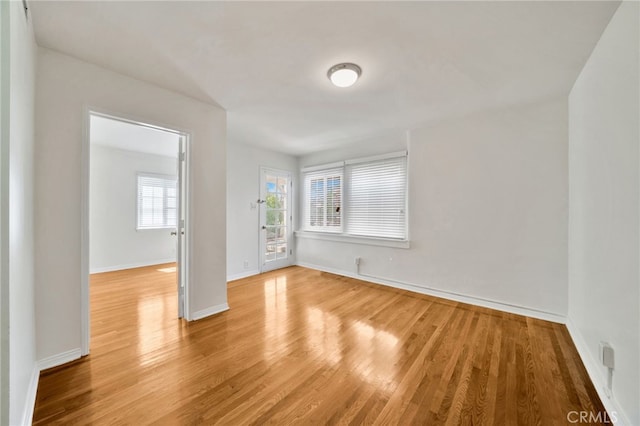 unfurnished room featuring light wood finished floors and baseboards