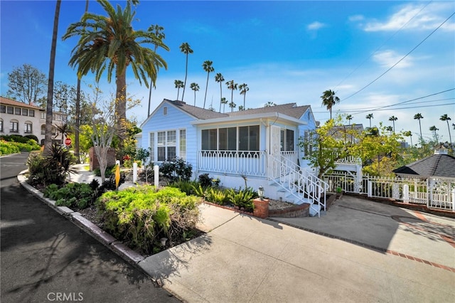 bungalow-style house featuring fence and a sunroom