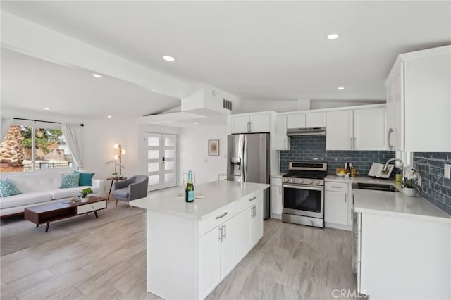 845 W Gateway Dr, Palm Springs, CA 92262 - kitchen with stainless steel appliances, a sink, open floor plan, under cabinet range hood, and tasteful backsplash