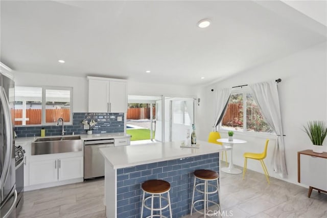 845 W Gateway Dr, Palm Springs, CA 92262 - kitchen featuring stainless steel appliances, a sink, a kitchen breakfast bar, tasteful backsplash, and light countertops