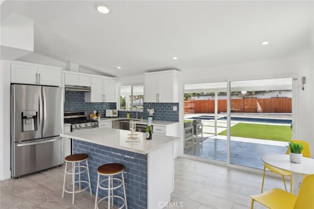 845 W Gateway Dr, Palm Springs, CA 92262 - kitchen with appliances with stainless steel finishes, a sink, backsplash, white cabinets, and a breakfast bar
