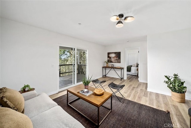 living area featuring light wood-style floors and baseboards