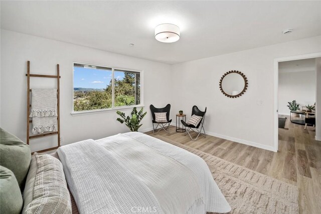 bedroom featuring baseboards and light wood-style floors