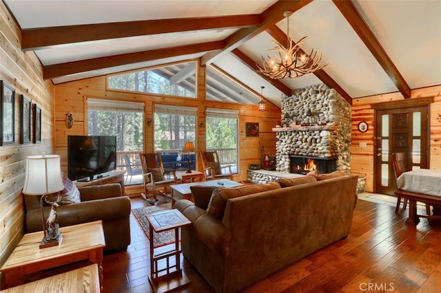 living room featuring dark wood-style flooring, vaulted ceiling with beams, wooden walls, and a fireplace