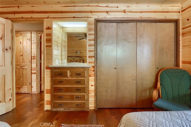 bedroom featuring wood walls and dark wood-type flooring