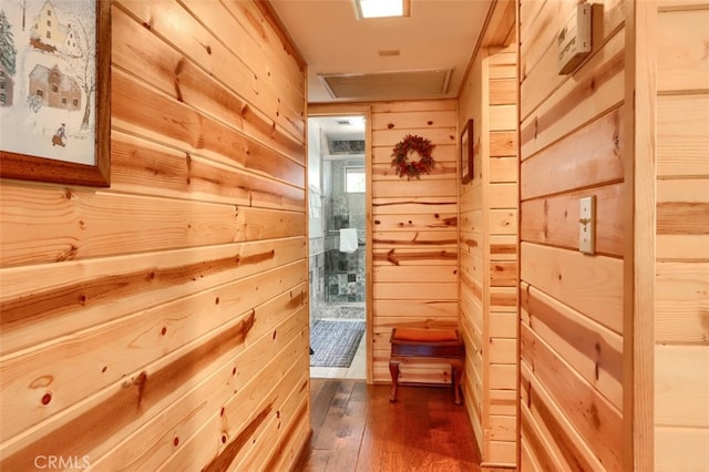 corridor featuring dark wood finished floors and wooden walls