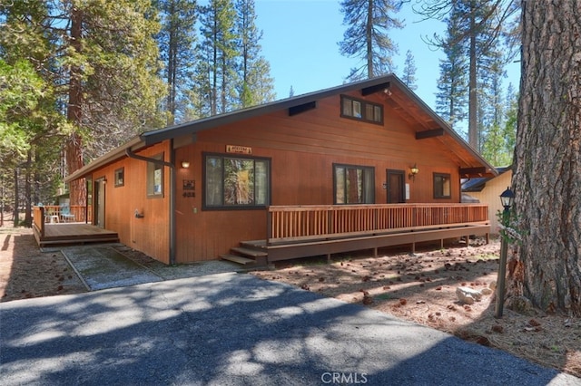 rear view of property featuring a wooden deck