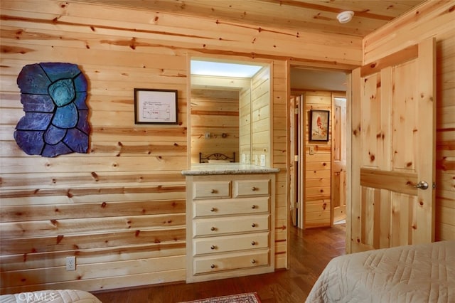 bedroom with dark wood-style floors and wooden walls