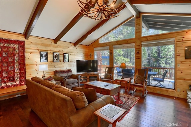 living room with hardwood / wood-style floors, a notable chandelier, wood walls, and beamed ceiling