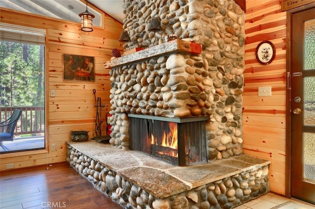 interior details with a fireplace, wood finished floors, and wooden walls