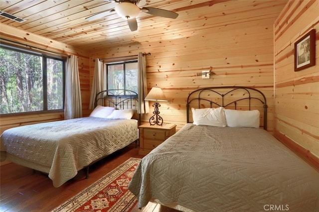 bedroom featuring wooden walls, wood ceiling, and wood finished floors